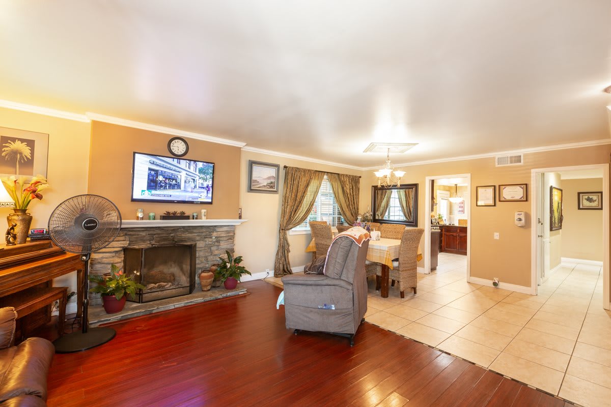 A cozy living room with a fireplace and television, featuring comfortable seating and elegant decor.