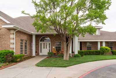 A brick building with a lush tree and a welcoming entrance path.
