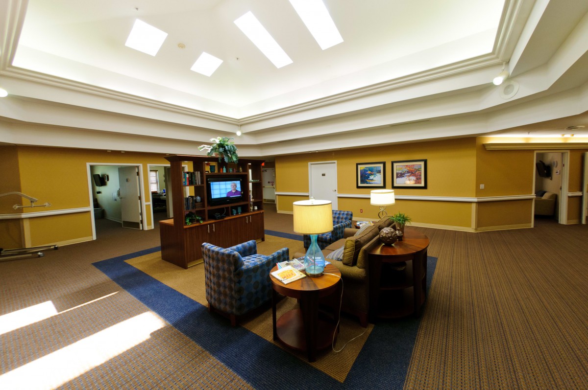A spacious and well-lit lounge area featuring comfortable seating, a television, and decorative elements.