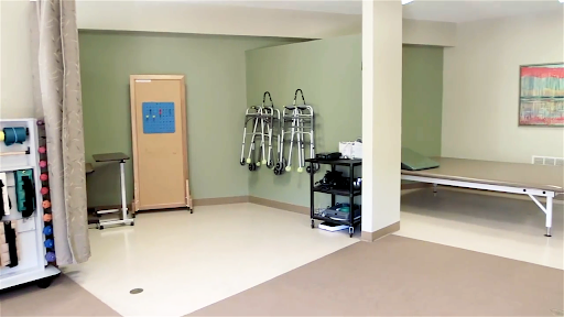 A well-lit therapy room equipped with medical tools and a reception area.