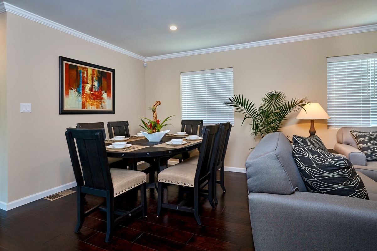 A cozy dining room with a round table, chairs, and decorative artwork on the wall.