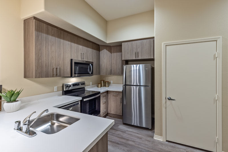 A modern kitchen with stainless steel appliances and wooden cabinets.