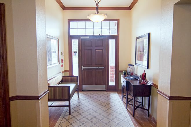 An inviting entrance with a bench and decor, leading to a wooden door.