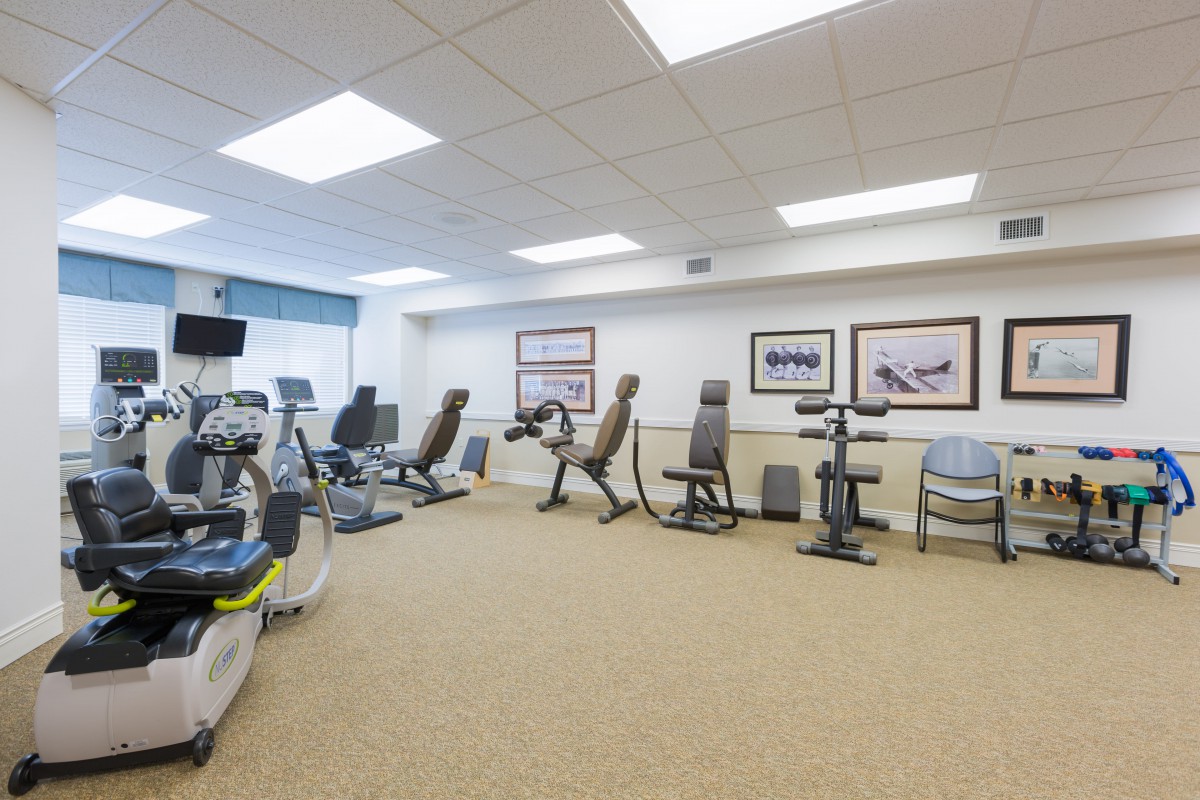 A well-lit fitness center with various exercise machines arranged neatly.