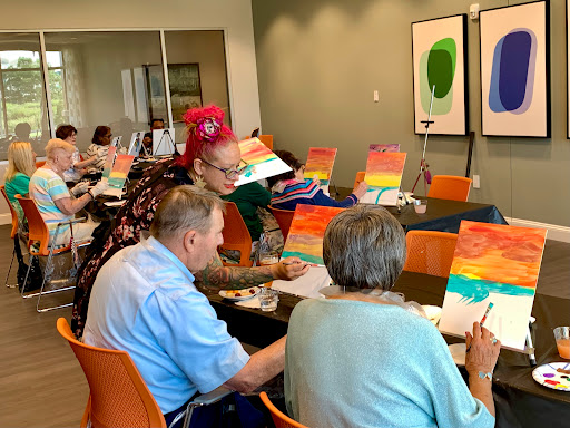 Seniors participating in a painting class, expressing their creativity with colorful canvases.