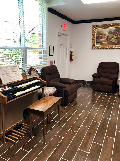 A cozy waiting area featuring comfortable recliners and a keyboard instrument.