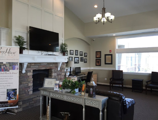 A cozy lobby area featuring modern furniture, a fireplace, and decorative elements.