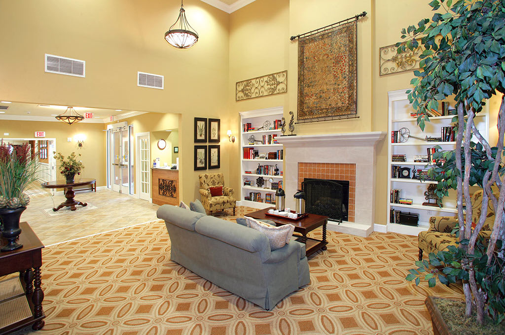 A cozy living room with a sofa, fireplace, and built-in bookshelves.