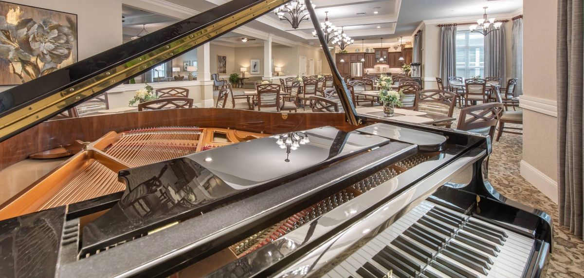 A grand piano in an elegant dining area with a sophisticated ambiance.