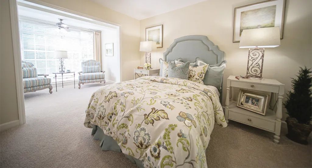 A cozy bedroom with a floral-patterned bedspread and elegant decor.