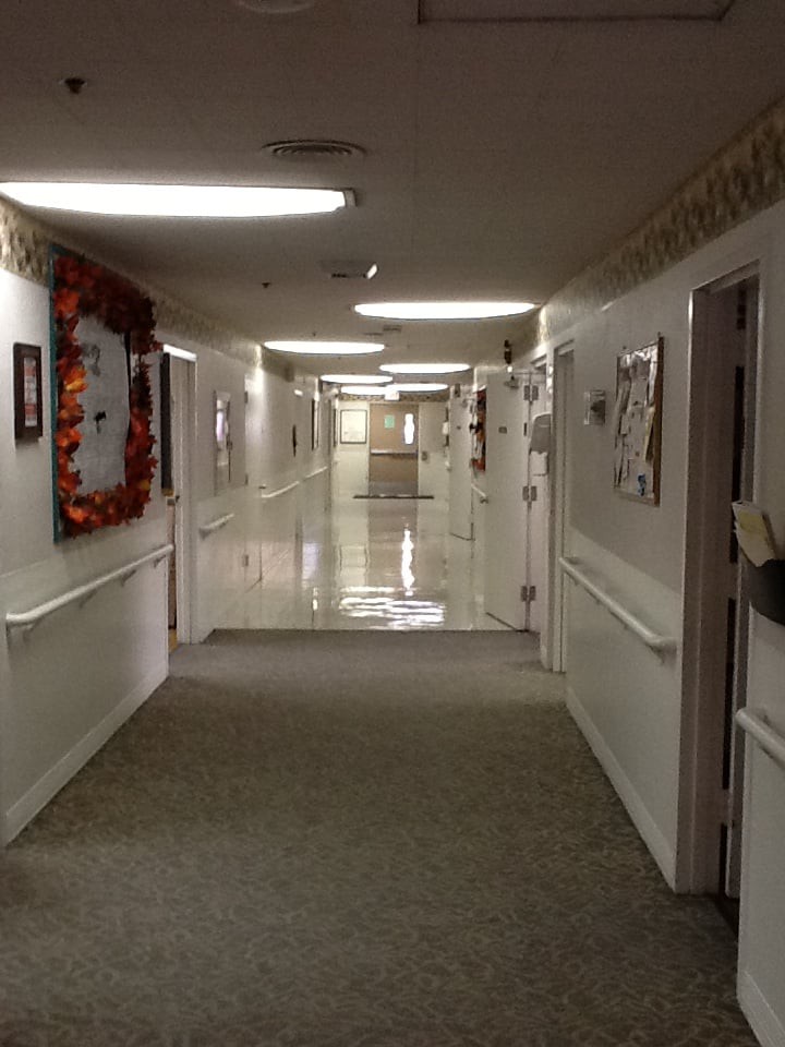 A hospital corridor with doors and bright lighting.
