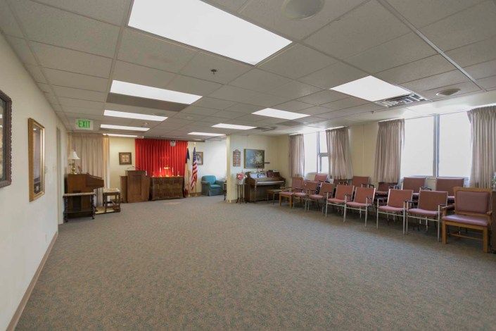 An empty meeting room with rows of chairs and a carpeted floor.