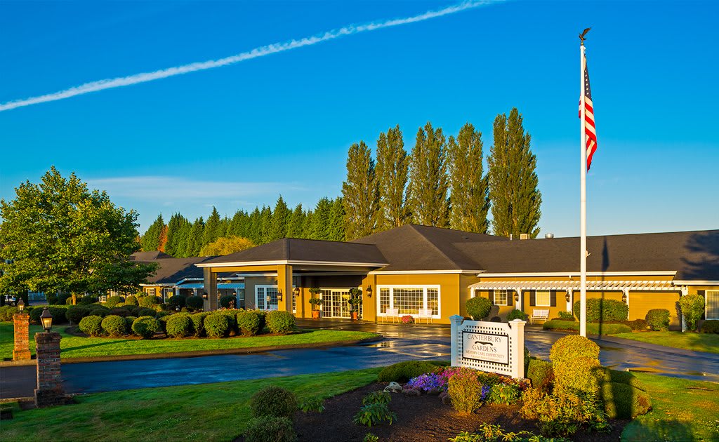 A well-maintained building surrounded by lush landscaping and a clear blue sky.