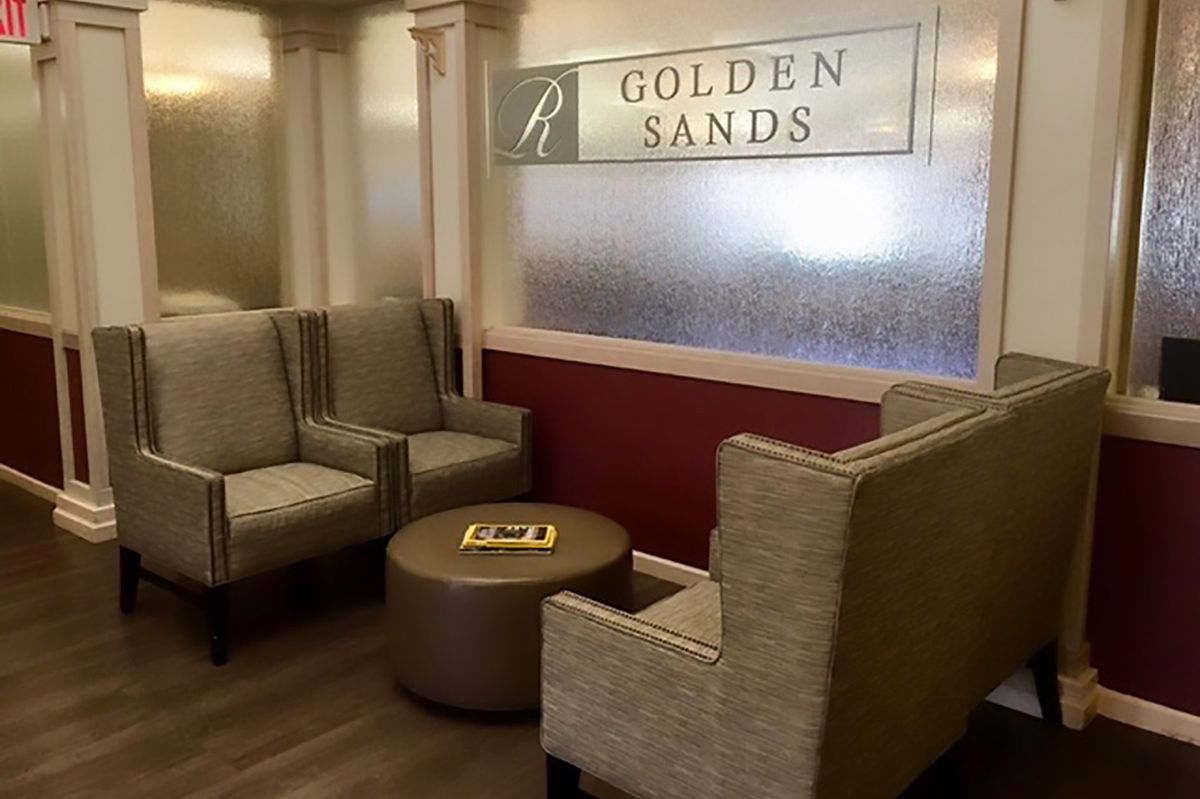 A cozy waiting area with comfortable seating and a sign reading 'Golden Sands'.