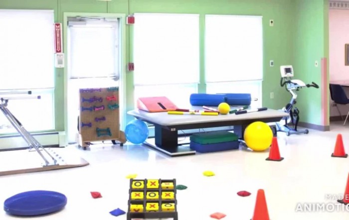 A brightly lit physical therapy room equipped with exercise materials and colorful objects.
