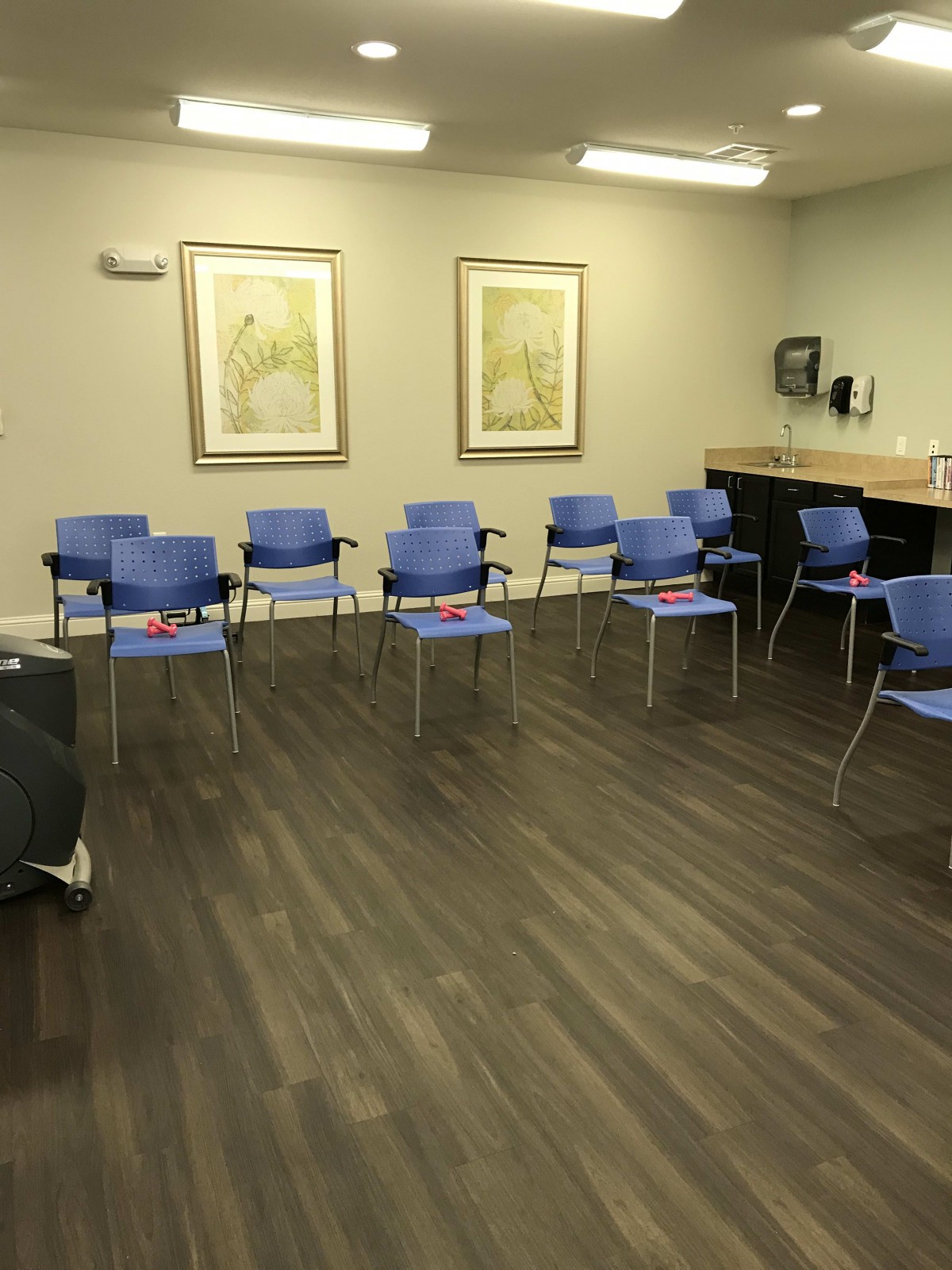 A spacious waiting room with blue chairs arranged in a circle.