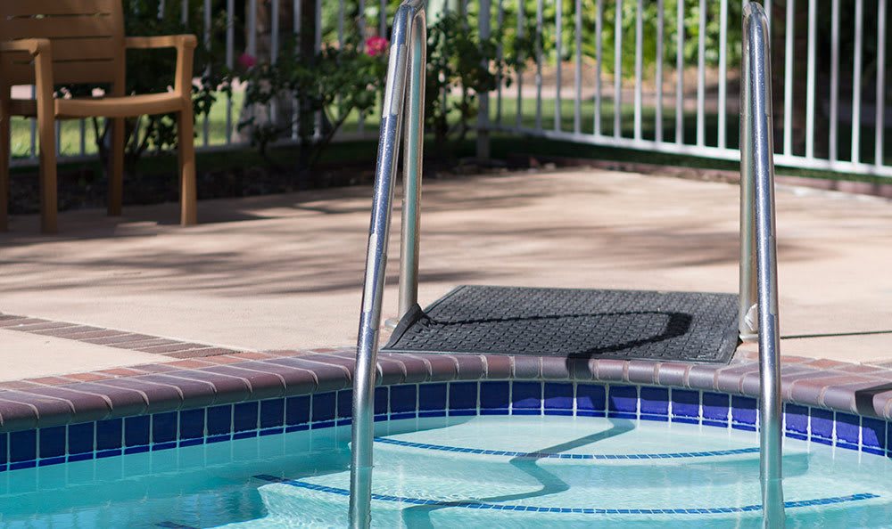 Close-up view of a swimming pool with steps and railing.