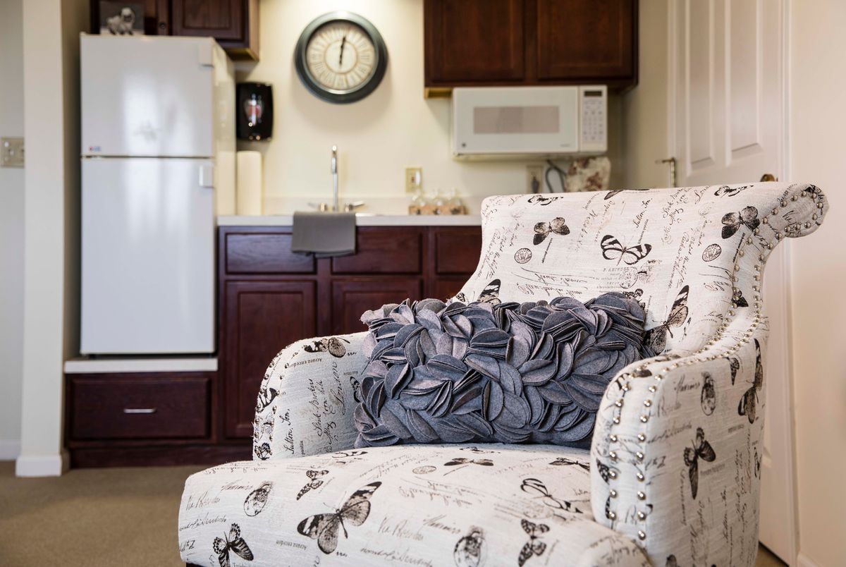 Cozy armchair in a kitchen setting with a decorative cushion.