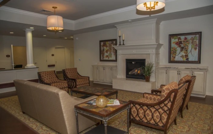 A cozy and elegantly decorated living room with a fireplace and comfortable seating.