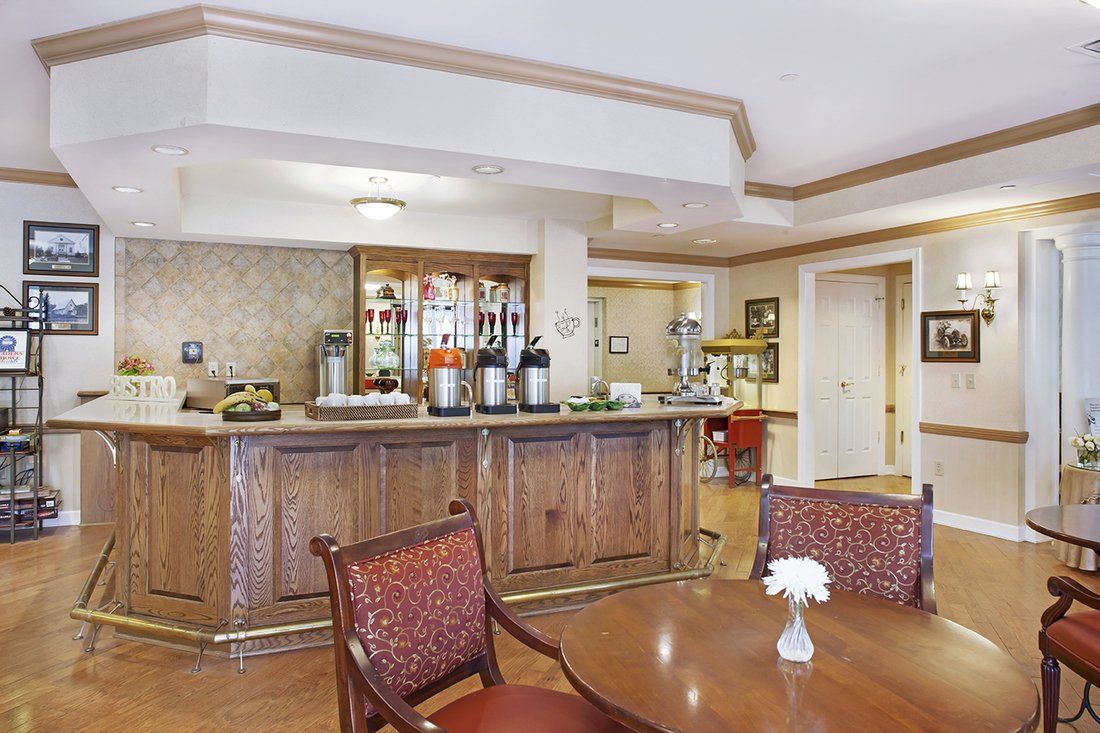 A cozy cafe interior featuring a coffee station and a seating area with wooden furniture.
