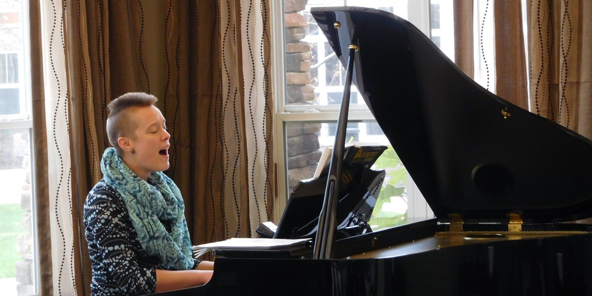 A person singing while playing the piano indoors.