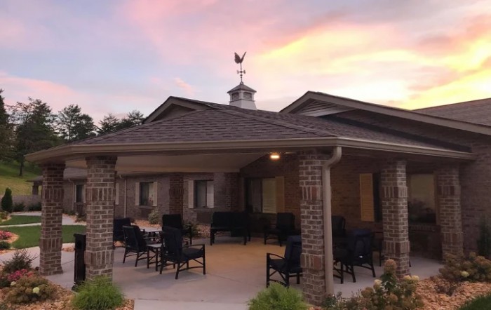 A cozy patio with seating under a beautiful sunset sky.