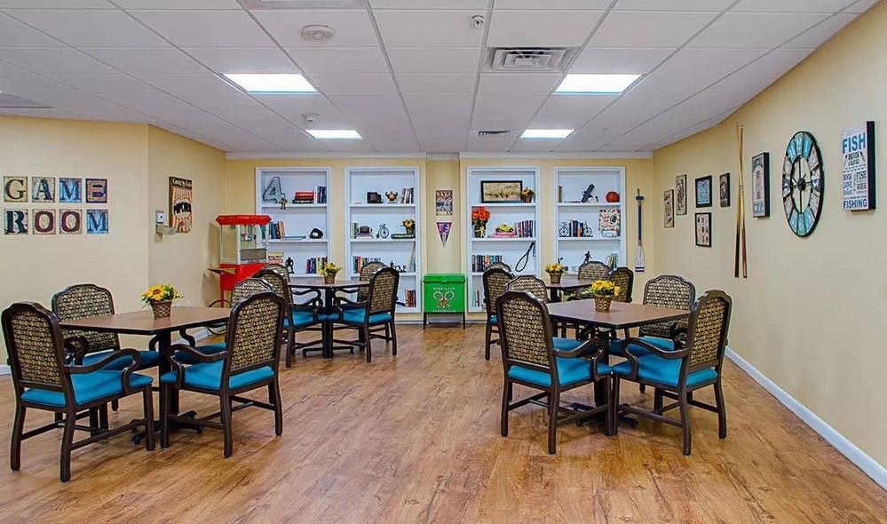 A well-organized room with tables and chairs, featuring bookshelves and various decorations.