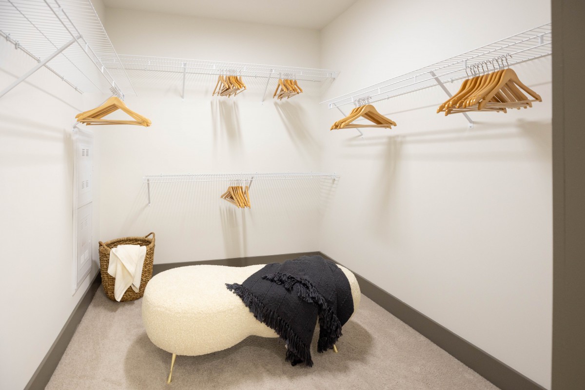 Minimalist dressing room with a bench and clothing hangers.