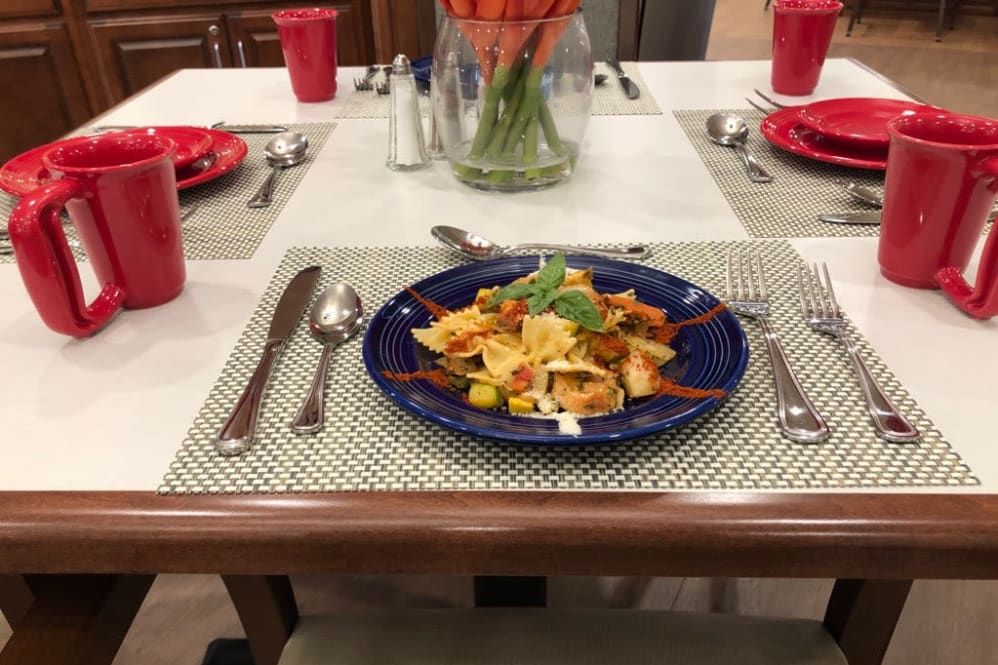 A beautifully set dinner table featuring a plate of pasta.