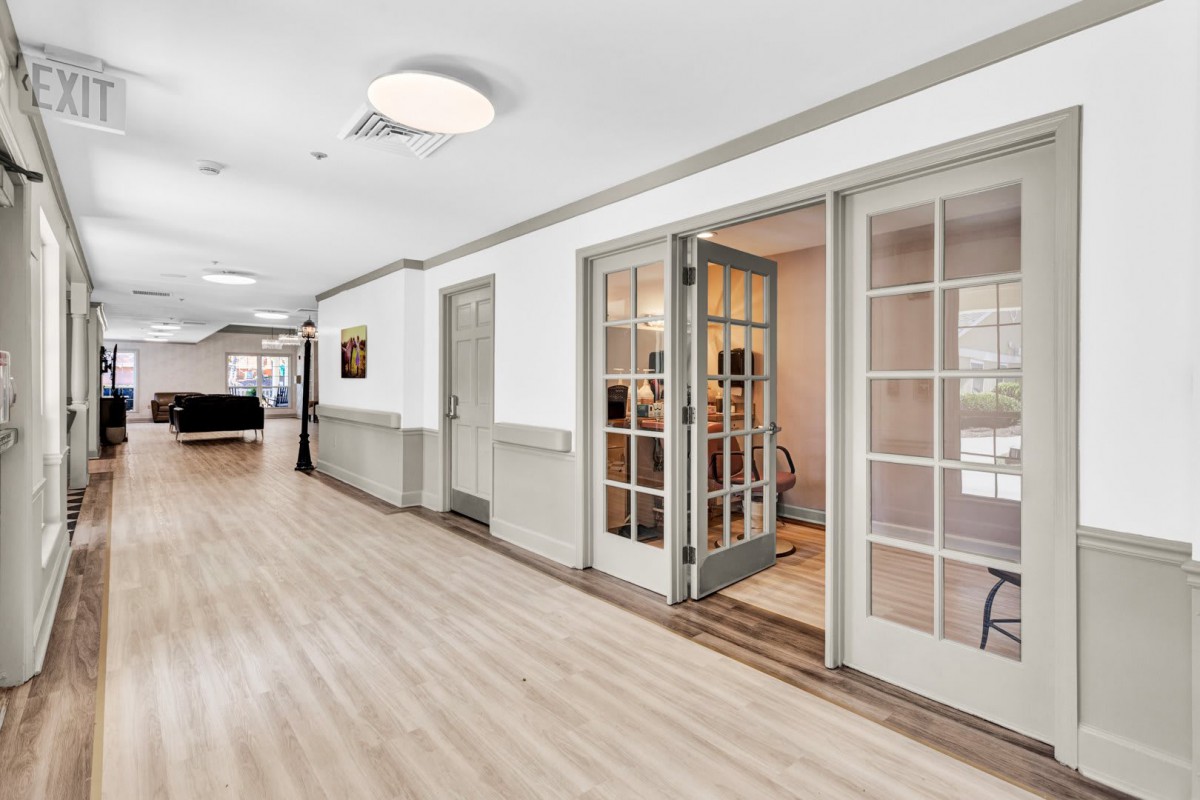 A modern hallway with wooden flooring and glass doors.