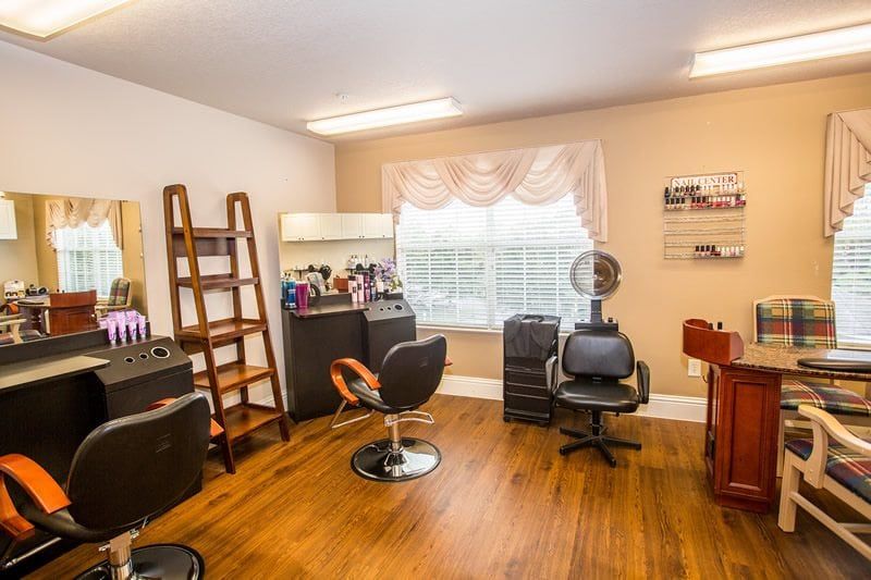 A cozy hair salon interior with styling chairs, a vanity mirror, and beauty products.