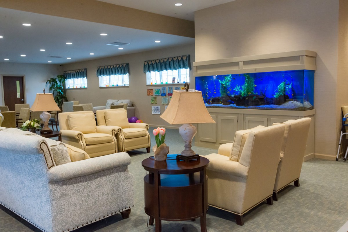 A cozy living room with comfortable sofas and a large aquarium.