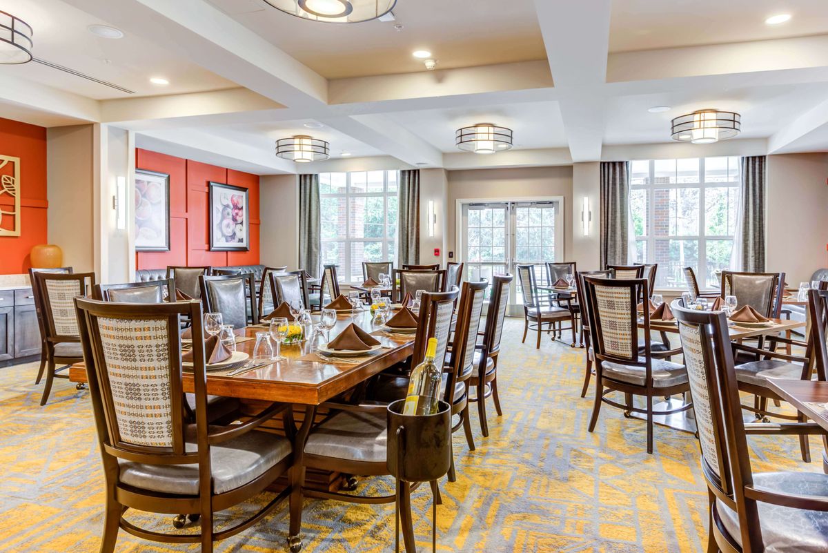An elegant dining room with neatly arranged tables and chairs in a bright, well-lit setting.
