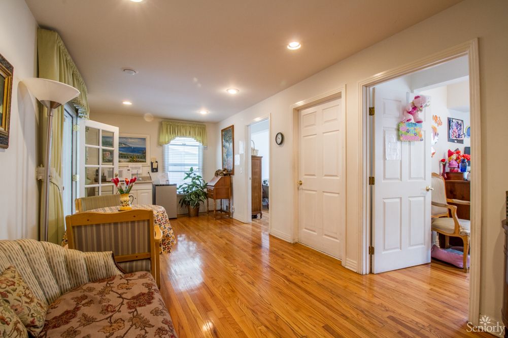 A spacious and well-lit living area with wooden floors and cozy furnishings.