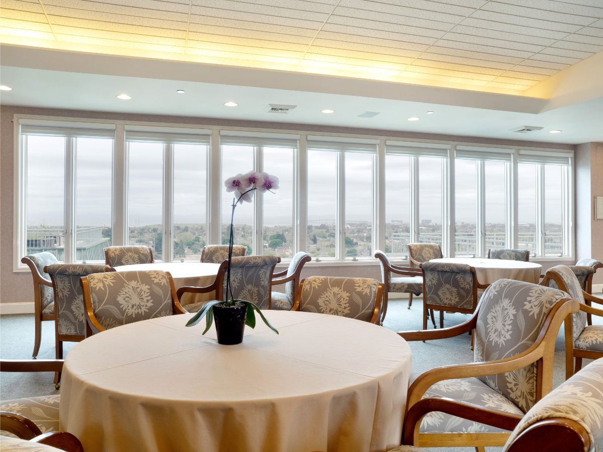 A spacious indoor dining area with large windows and elegant table settings.