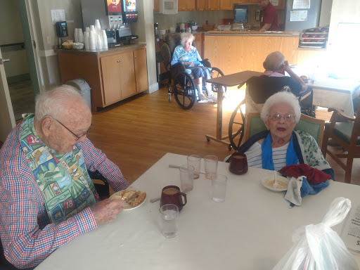Elderly residents enjoying a meal together in a care facility.