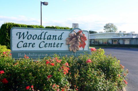 Entrance of Woodland Care Center with surrounding flowers.