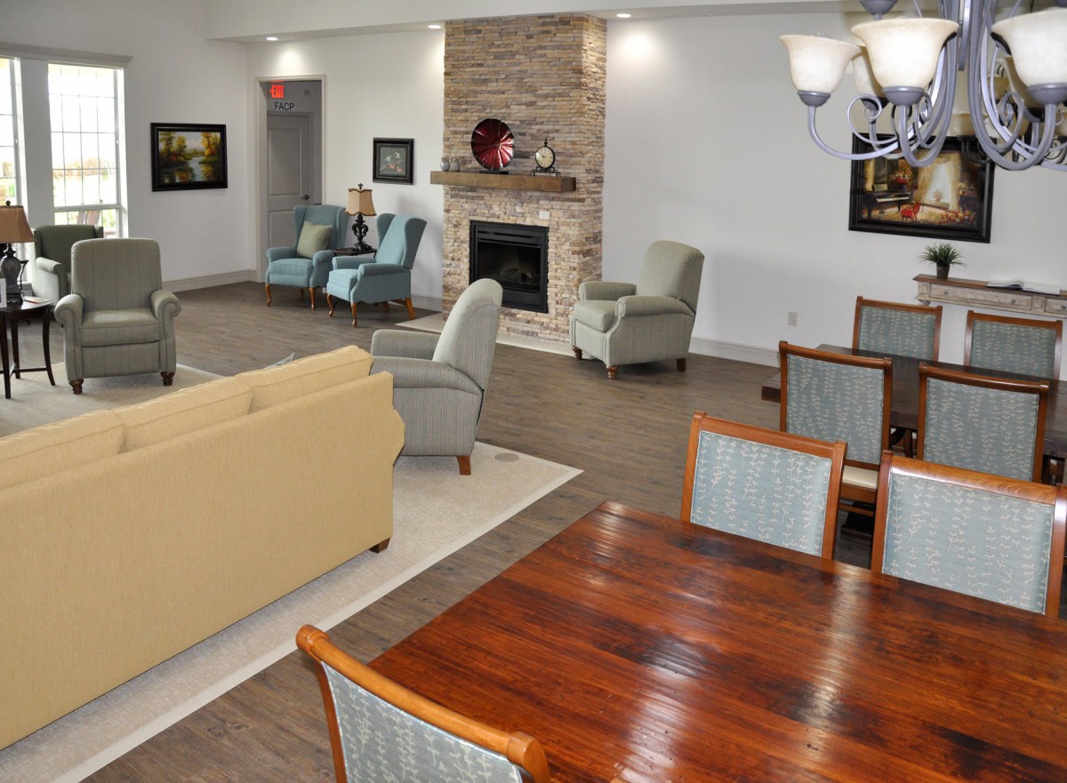 A spacious living room with a modern design, featuring comfortable seating and a cozy fireplace.