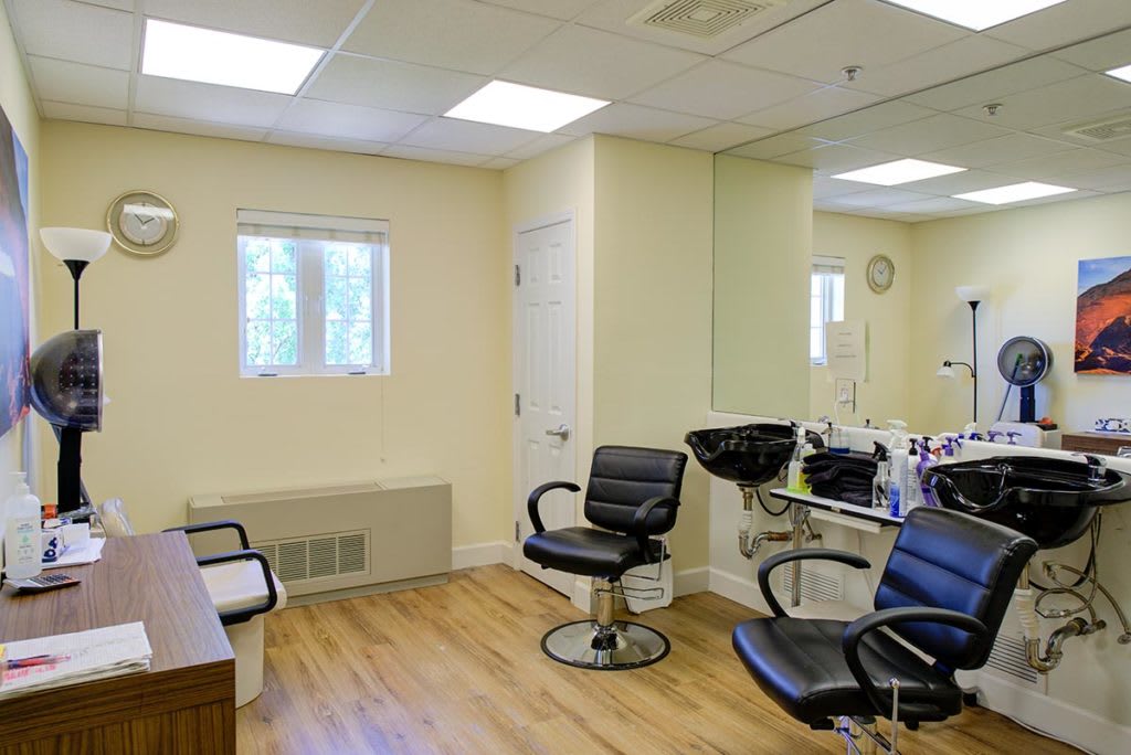 An interior view of a hair salon with styling chairs and mirrors.