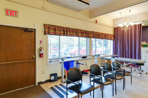 A bright and inviting waiting area featuring rows of chairs and large windows.