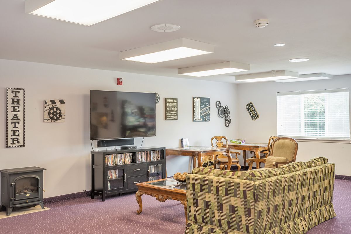 A modern living room with a large television, comfortable seating, and stylish decor.