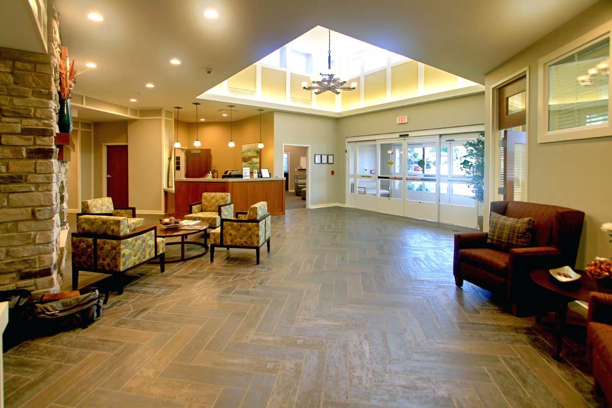 A spacious and well-lit lobby area with seating and a reception desk.