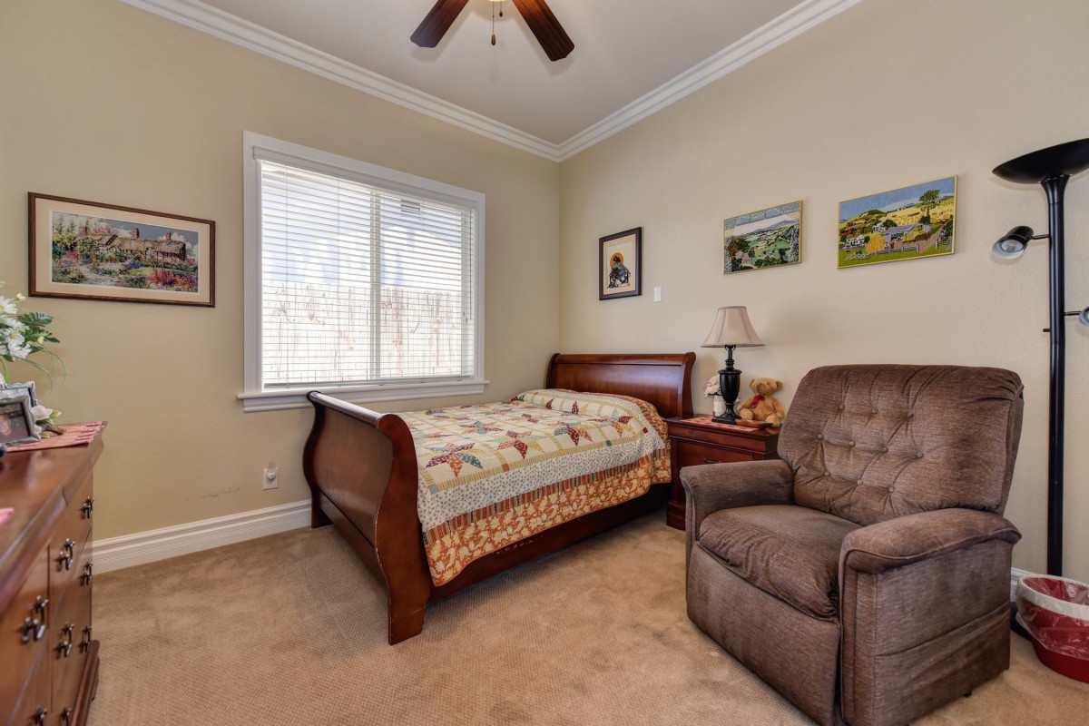 A cozy bedroom with a bed, armchair, and decor.