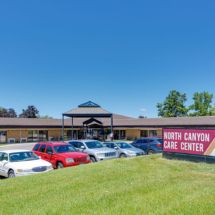 A care center with a parking lot in front and a clear blue sky.