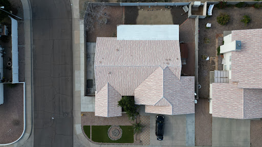 An aerial view of a residential house showcasing its roof structure and surrounding area.