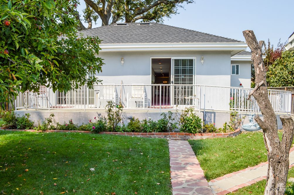 A cozy residential house with a well-maintained lawn and garden path.