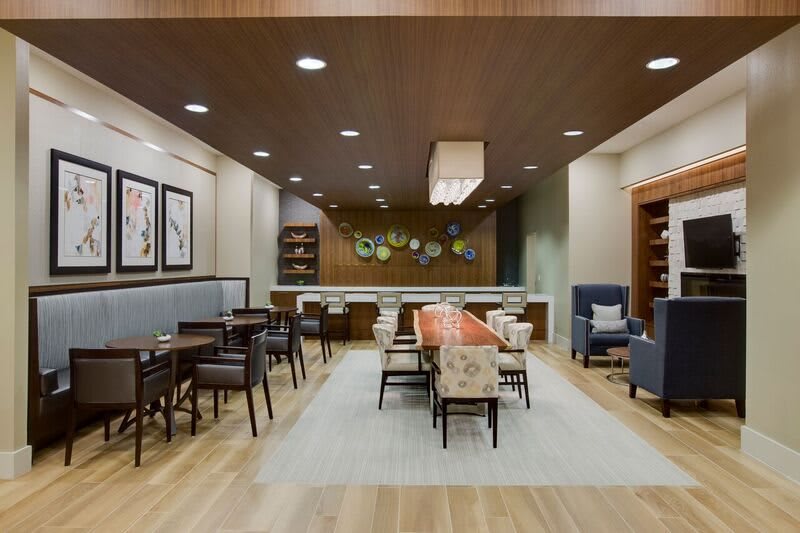 A modern lounge area featuring stylish furniture, wood flooring, and contemporary artwork.