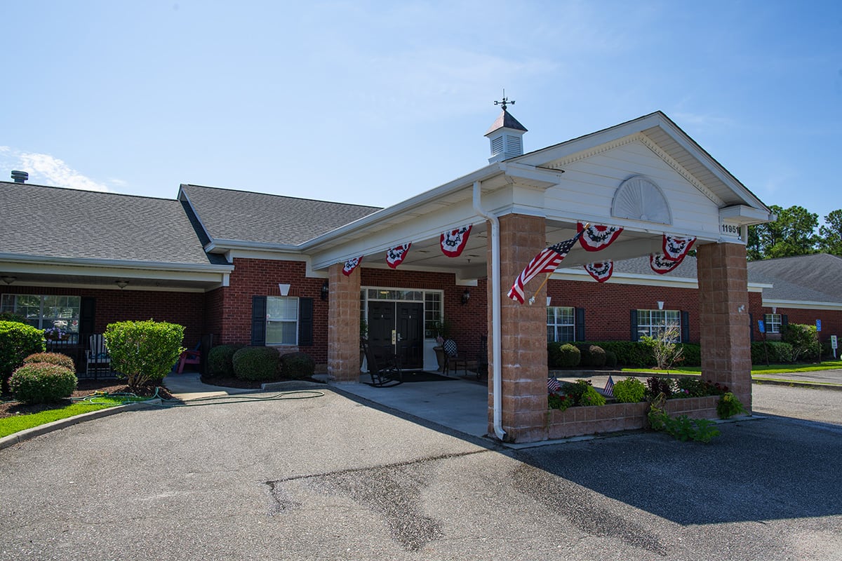 A brick building entrance adorned with patriotic bunting in daylight.