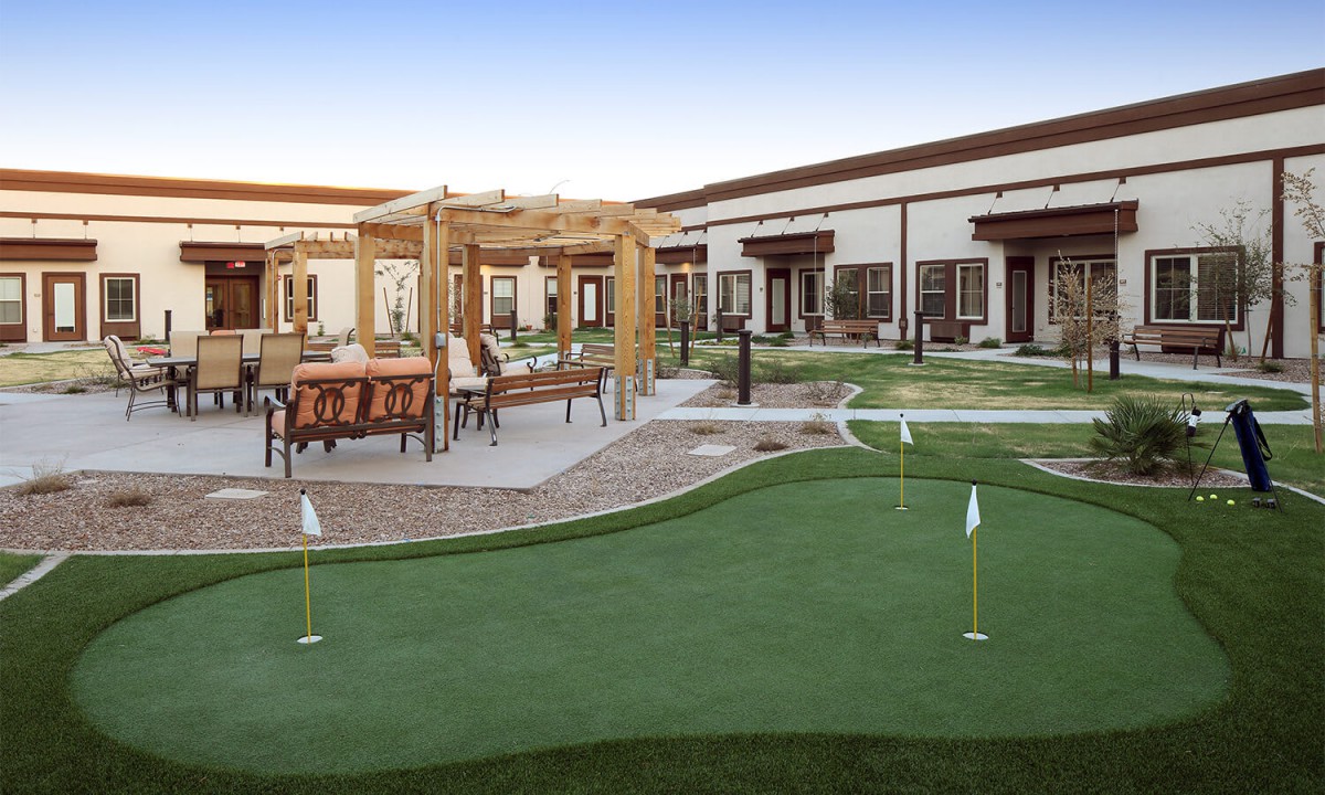 A scenic outdoor recreation area featuring a putting green and patio seating.