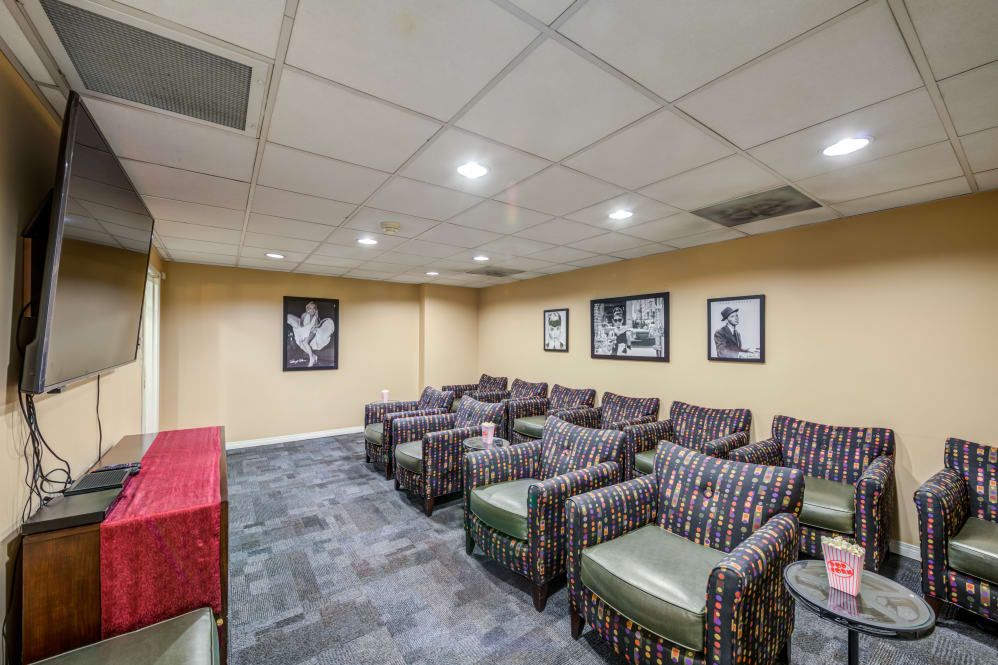 A cozy lounge area with multiple armchairs and framed pictures on the walls, suitable for meetings or relaxation.